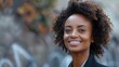 © Pat J. - Empowered female in a sleek suit, smiling happily while looking to the side, in an urban outdoor environment