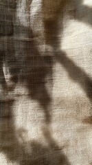 Poster - Soft morning light streams through, casting delicate shadows on the textured fabric, creating an intricate dance of light and darkness in a serene space