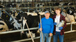 © JackF - Old and young caucasian men farmers standing in cowshed.