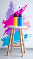 Poster - Yellow and Blue Paint Bottles on White Stool Against Abstract Brushstroke Background