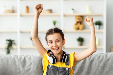 Poster - Academic Achievement Concept. Portrait Of Excited Pupil Girl Sitting In Living Room With Laptop Gesturing Yes Shaking Clenched Fists Getting A-Grade During Webinar At Home. Online School Tests Concept