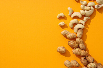 Wall Mural - Assortment of different nuts on an orange background