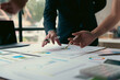 © Crystal - Business people analyzing financial charts and graphs using pens in the office