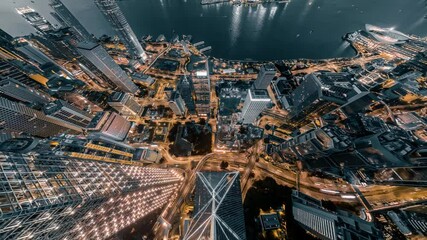 Poster - A stunning 4k still video captures a zoomed-out aerial view of Hong Kong's vibrant cityscape at night.  Illuminated skyscrapers and intricate road networks create a mesmerizing scene.