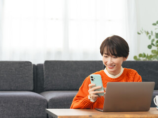 Leinwandbilder - スマホ、スマートフォン、アプリ、SNS、通知、メール、決済、認証、顔認証、通販、通信販売、eコマース、ECサイト、銀行、ネットバンキング、オンライン、web、送金、笑顔、女性、ミドルエイジ、主婦、日本人、買い物、ショッピング、ネット、座る、リラックス、くつろぐ、ライフスタイル、DX、デジタル、IT、ノートパソコン、PC、データ、共有、送信、2段階認証、2FA、暗証番号、パスコード、パスワード、動画