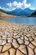 © Duskcraft - Cracked earth meets blue water under a bright sky with mountains in the distance landscape