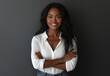 © muhammadarslan - Portrait of a smiling business woman standing with arms crossed on a grey background, wearing a white shirt and jeans. A female entrepreneur