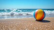 © olegganko - Bright beach ball resting on sandy shore with ocean waves and clouds in the background