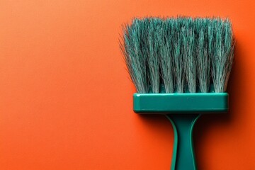 Poster - Brush resting on vibrant orange wall, capturing the essence of home improvement and creativity