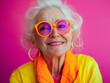 © sam - studio portrait of happy senior retired woman wearing colourful clothes, isolated on pink background