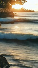 Wall Mural - waves crashing against rocky shore during sunset in a serene coastal landscape