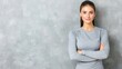 © artzone - Confident Young Woman in Grey Shirt Against a Textured Grey Wall