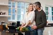 © peopleimages.com - Love, couple and cooking in kitchen with support for healthy online recipe, dinner preparation and bonding together. Home, mature people and affection with lunch meal, organic food and relationship