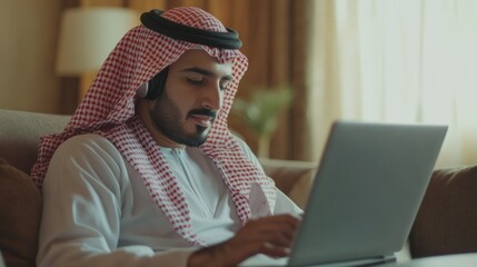 Poster - Young man in traditional attire working on laptop indoors