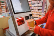 © EdNurg - Customer scanning groceries at self checkout kiosk in supermarket