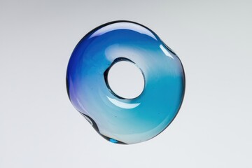 Aufkleber - A translucent blue glass sculpture, shaped like a donut with a central hole, features a gradient of color.