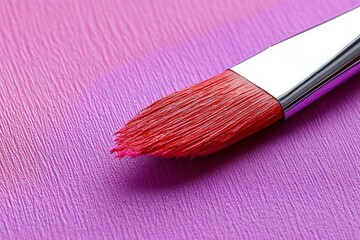 Aufkleber - Bright red paintbrush resting on a vibrant purple canvas creating artistic expression and inspiration