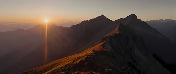 Wall Mural - Inspiring closeup of a sunrise breaking over a mountain ridge casting warm light on the landscape and signaling new beginnings