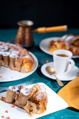 Wall Mural - A piece of banana cake or pie and a cup of Turkish coffee on a white plate on a turquoise background. French dessert on the table. Vertical photo.