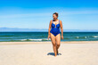 © Jacek Chabraszewski - Summer vacations. Beautiful mature woman in swimsuit walking on sandy beach. Front view