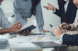 © Wicitr - Brainstorming and Collaboration: A diverse group of professionals engage in a passionate discussion, meticulously reviewing documents and data as they strategize and collaborate.