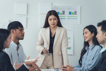 Wall Mural - Team Meeting Brainstorm: A focused team of business professionals engages in a productive brainstorming session, led by a confident female leader. The atmosphere is collaborative and positive.