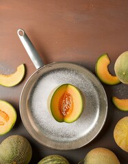 Wall Mural - Halved cantaloupe in a metal pan with other cantaloupes.