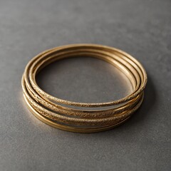 A stylish stack of thin gold bangles with minimalist engravings.