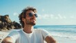 © The 2R Artificiality - Young man in sunglasses relaxes on a sunny beach enjoying the ocean view with a carefree smile and casual summer attire