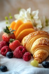 Wall Mural - A colorful arrangement of croissants, strawberries, oranges, raspberries, and blueberries on a white cloth