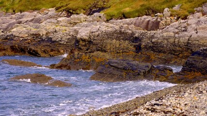 Wall Mural - Arranmore Island in Donegal IrelandA stunningly beautiful coastal view showcasing rugged rocks, crashing waves, and vibrant lush greenery along the shore