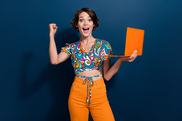 Aufkleber - Photo of young girl hold laptop bought new products in online supermarket raised fist up screaming hooray isolated on blue color background