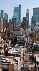 Wall Mural - Lower multistoried building at the backdrop of amazing skyscrapers. Sunny cityscape of New York. Top view. Vertical video