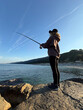 © Sunny studio - Young happy woman is fishing at sea during spring vacation