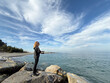 © Sunny studio - Young happy woman is fishing at sea during spring vacation