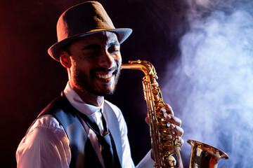 Smiling saxophonist with hat and smoke on background