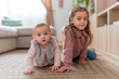 © Martí Rosselló - Little sisters playing on the floor at home, A 7-month-old baby and a 4-year-old girl crawling in the living room, with natural light and a cozy atmosphere.