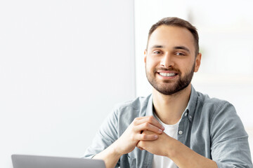 Poster - Positive male teacher giving English lesson online, using laptop at home office. Young Caucasian tutor explaining grammar rules to students on web indoors. Modern remote education concept