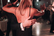 © tsuguliev - Couples dancing traditional latin argentinian dance milonga in the ballroom, tango salsa bachata kizomba lesson in red and purple lights, performance rehearsal, evening dance school class festival