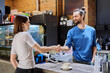 © Valerii Honcharuk - Young man cafe worker shaking hands with woman client customer colleague in coffee shop