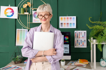 Poster - Young female graphic designer with laptop in office