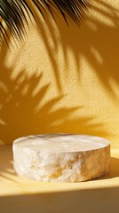 Poster - Stone podium on yellow background with palm tree leaves casting shadows, creating a tropical and luxurious atmosphere ideal for showcasing beauty or skincare products