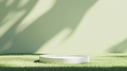 Poster - White cylinder podium resting on a lush green grass field, casting a delicate leaf shadow against a light green background, creating an ideal setting for product presentation and advertisement