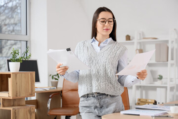 Wall Mural - Young businesswoman with report in office