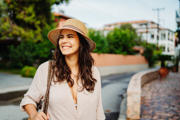 Young caucasian woman is going to the beach with straw bag	
