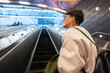 © Alvaro Lavin/Stocksy - Young woman going up escalator in New York City subway station
