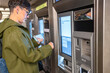 © Alvaro Lavin/Stocksy - Woman buying metrocard at ticket vending machine in New York City