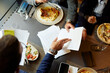 © Boris Jovanovic/Stocksy - Paperwork over lunch in the restaurant