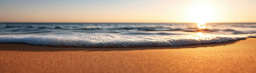 Poster - calm ocean wave gently rolling onto shore, symbolizing tranquility and peace at sunset. golden sand reflects warm hues of sun