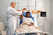 © Danil Nevsky/Stocksy - Doctor checking arm mobility of patient in hospital bed
